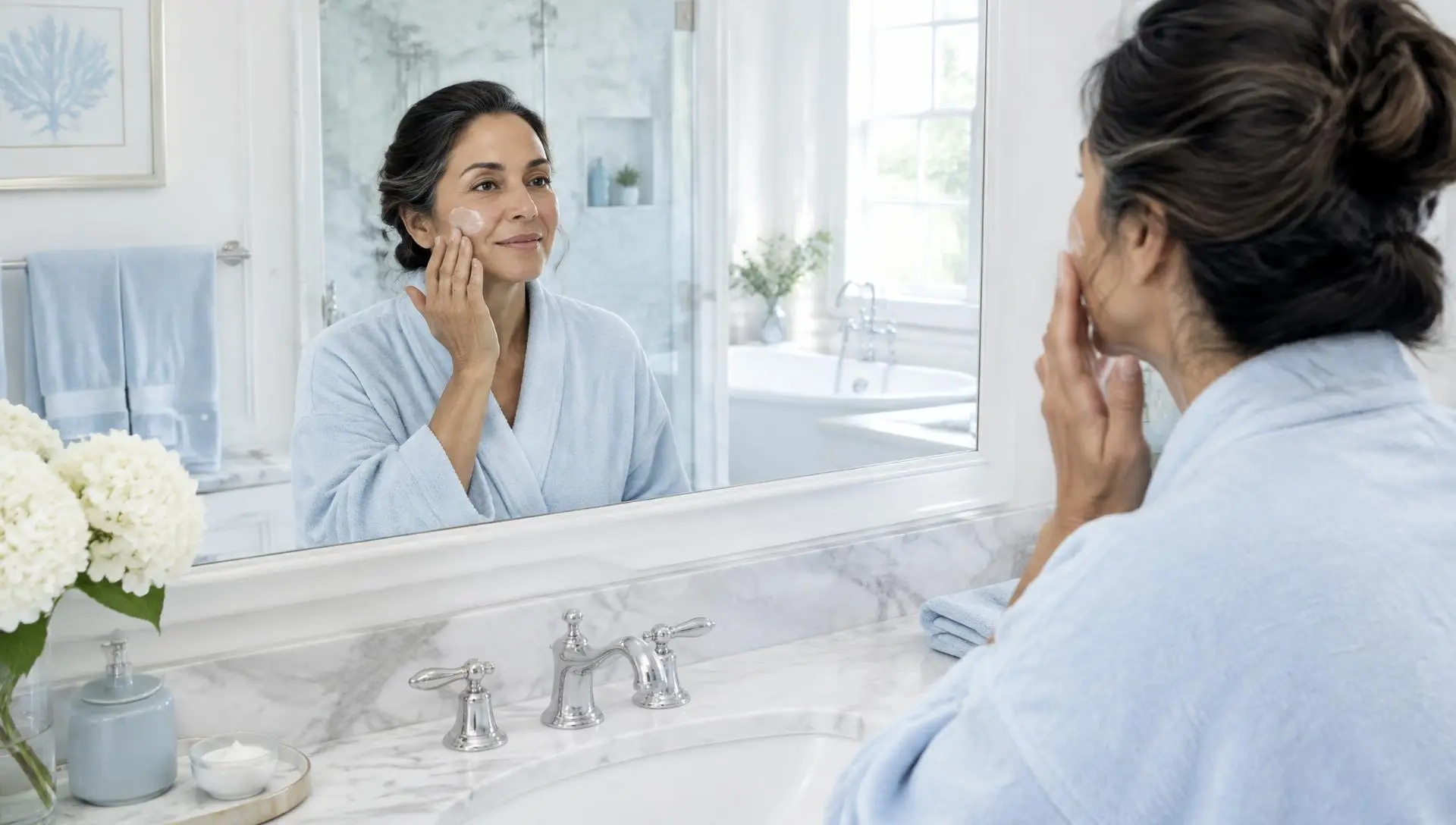 Mujer aplicando crema frente al espejo de su baño